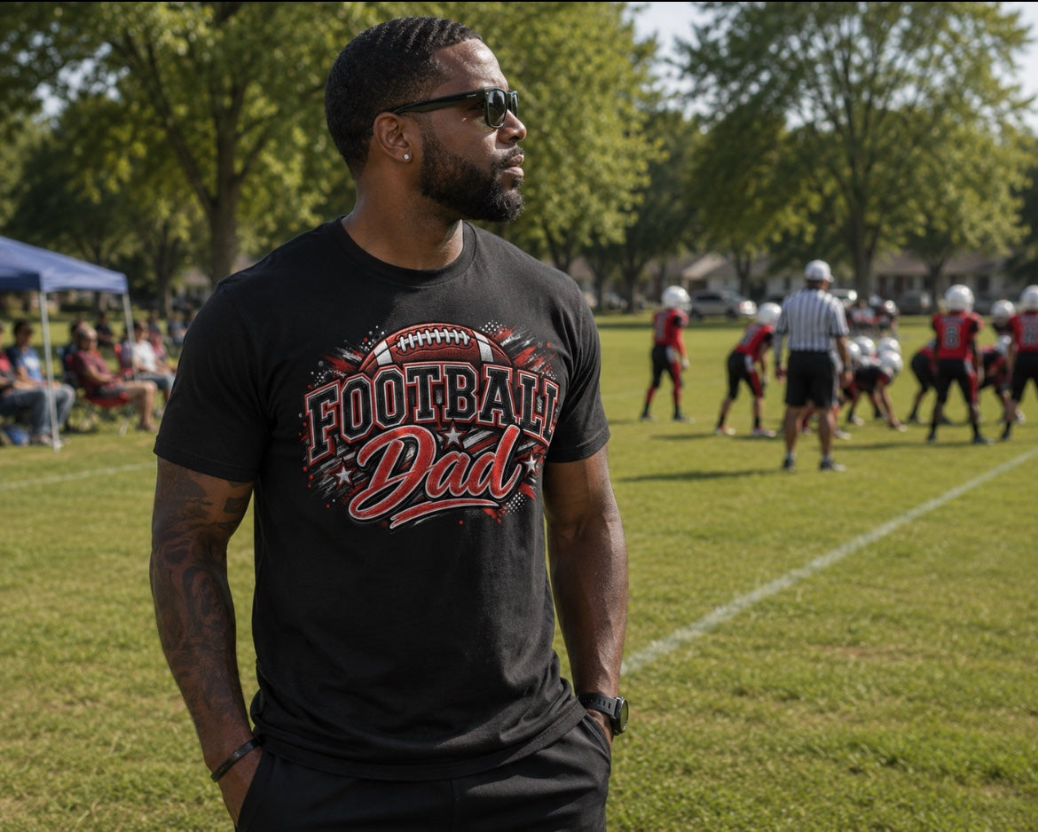 Football Dad white graphic tee with collegiate-style design worn at youth football game